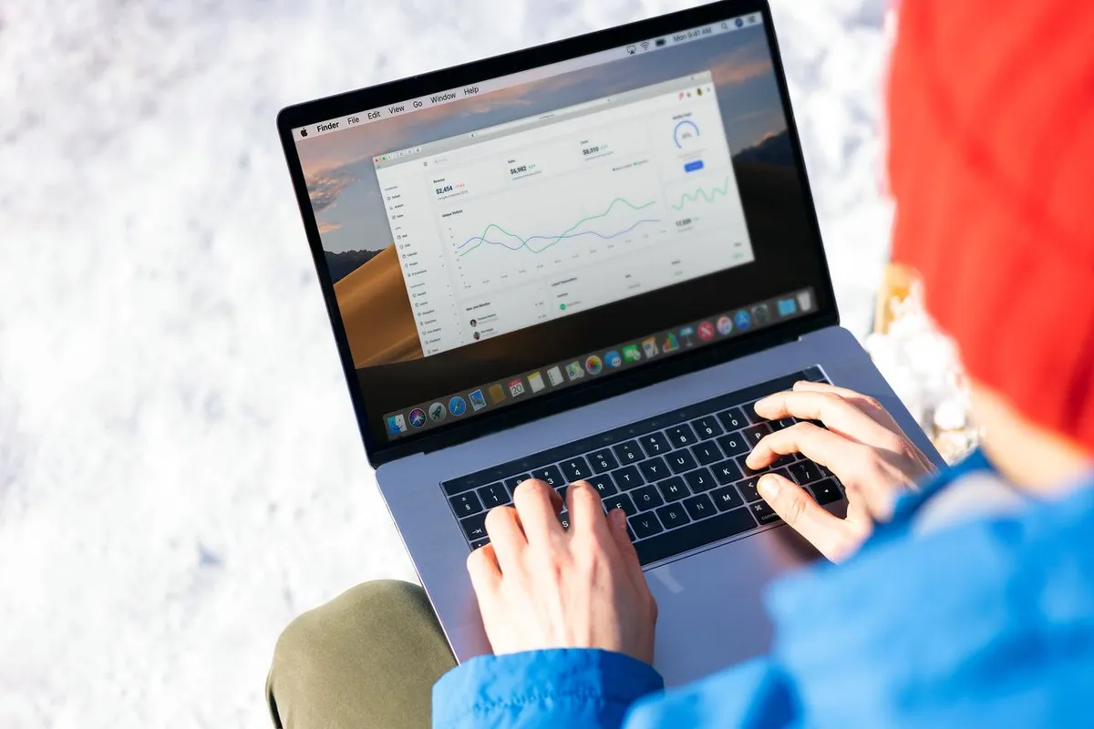Developer reviewing custom SaaS analytics dashboard, revenue graphs, and web application on laptop