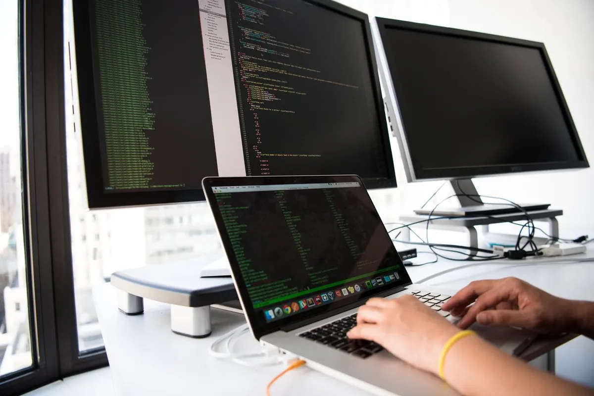 Developer workspace with multiple screens showing shipped software stack